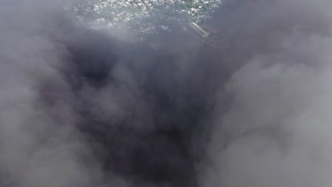 Drone-passes-through-dense-cloud-of-black-smoke-of-burning-building-on-fire
