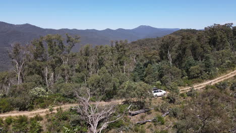 Aerial-Drone-shot-Side-View-of-4WD-Driving-on-dirt-road-up-a-mountain-near-Lake-Eildon,-Victoria-Australia