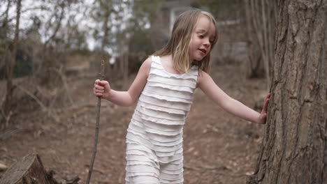 Cute-little-girl-playing-and-exploring-in-a-forest-setting-in-slow-motion
