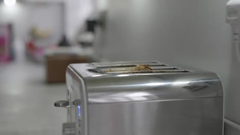 A-single-slice-of-toast-is-inserted-into-a-toaster