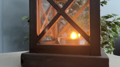 Candle-in-wooden-Lantern-box-inside-home-during-the-day-close-up-for-remembrance