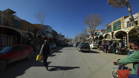 Menschen-Und-Fahrzeuge,-Die-Mittags-Auf-Den-Straßen-Von-Bamyan-In-Afghanistan-Vorbeifahren-–-Totale
