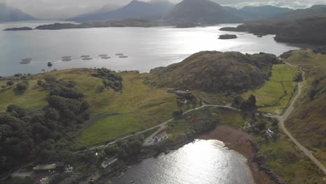 Aerial-drone-shot-of-beautiful-scottish-landscape-in-north-highlands-with-lake-bay-and-green-mountains-in-sunny-day-uk
