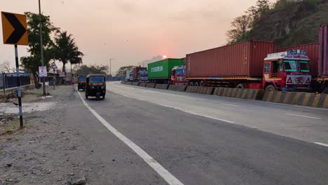 Indian-Auto-rickshaw-breaking-traffic-rules,-driving-on-wrong-way-on-Road-heavy-traffic-on-one-side-on-Indian-Highway-road-with-big-trucks,containers,big-vehicles-with-goods