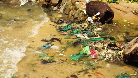 Water-pollution,-dirty-sea-shore-with-floating-plastic-trash,-microplastics-and-waste-close-up