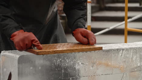 Pan-left-on-ice-sculptor-artist-using-nail-board-to-shave-ice-block,-Slow-Motion