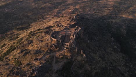 Epische-Luftaufnahme-über-Die-Ruinen-Der-Monsanto-Festung-Bei-Sonnenaufgang,-Portugal