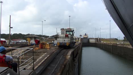 Vista-Del-Casco-Del-Barco-Y-La-Locomotora-Tirando-Lentamente-Del-Barco-En-La-Cámara-De-Las-Esclusas-De-Gatún,-Canal-De-Panamá