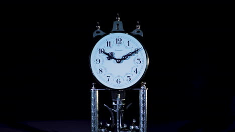 close-up-of-an-old-clock-in-low-key-studio-lighting,-backward-dolly