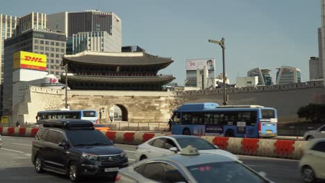 Traffic-On-Road-With-Sungnyemun-Gate-And-High-rise-Buildings-In-Background-In-Seoul,-South-Korea