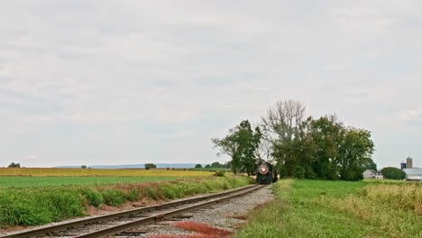 An-Antique-Restored-Locomotive-and-Passenger-Coaches-Approaching-on-a-Cloudy-Day-Traveling-Thru-the-Countryside