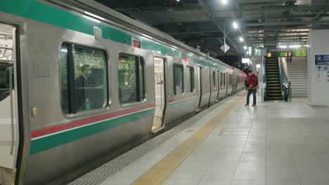 Pasajeros-Caminando-En-Una-Plataforma-Vacía-Y-Subiendo-A-Un-Tren-En-La-Estación-De-Tren-En-Sendai,-Japón
