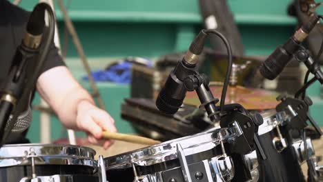 Band-Drummer-Beating-On-The-Drum-Set-With-Instrument-Microphones-To-Boost-Volume
