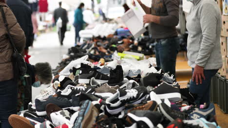 Gente-Comprando-Zapatillas-A-La-Venta-En-El-Mercado-Callejero-Durante-El-Día