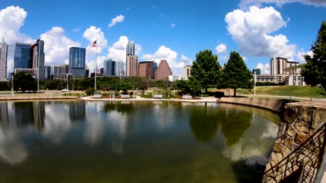 A-slow-smooth-pan-of-white-puffy-clouds-and-the-Austin-Skyline-reflecting-in-the-Palmer-Pond