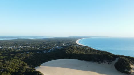Hoher-Drohnenblick-Mit-Blick-Auf-Den-Carlo-Sand,-Der-In-Richtung-Tin-Can-Bay,-Queensland,-Australien,-Ausgeblasen-Wird