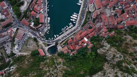 Cinematic-birdseye-aerial-over-the-old-town-and-the-harbour-in-Kotor-Montenegro-a-popular-destination-in-the-Adriatic-Sea-for-luxury-superyachts