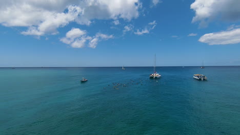 Aerial-FPV-Drone-Approaching-Sail-Boat-and-snorkelers-in-the-Pacific-Ocean-off-Oahu,-Hawaii