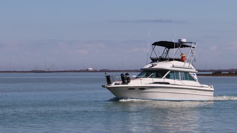 Cabin-cruiser-navigating-through-small-storm-islands-in-the-Gulf-Intercoastal-Waterway-near-Padre-Island-on-a-bright-winter-afternoon