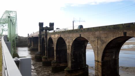 Public-train-crossing-Runcorn-bridge-old-castle-turret-building-tower-right-to-left-journey
