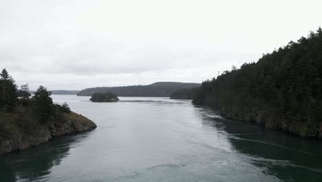 Passing-slowly-over-dark-green-waters-of-Deception-Pass-and-Puget-Sound,-Washington,-aerial