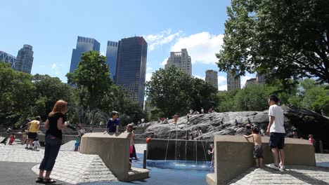 Kids-playing-at-cityscape-playground-in-Central-Park-in-Manhattan,-New-York-City