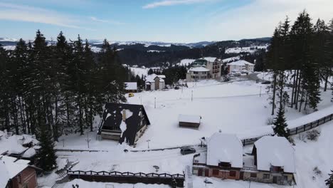 Centro-De-Esquí-De-Montaña-Con-Hoteles,-árboles,-Coches,-Cubierto-De-Nieve