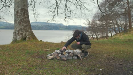 Wideshot-young-man-preparing-campfire-on-island-in-Winter