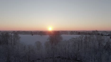 Rise-over-Snow-Covered-Field-and-Trees-to-Reveal-the-Sunrise