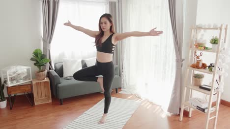 Asian-women-relax-with-yoga-exercise-and-stretching-in-the-living-room