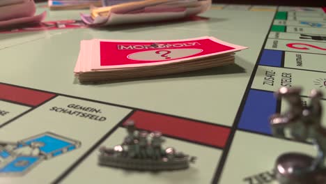Hand-Pick-Card-On-Deck-While-Playing-Monopoly-Board-Game-At-Home