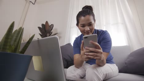 Asian-women-are-using-smartphone-with-a-profile-for-online-shopping-on-a-laptop