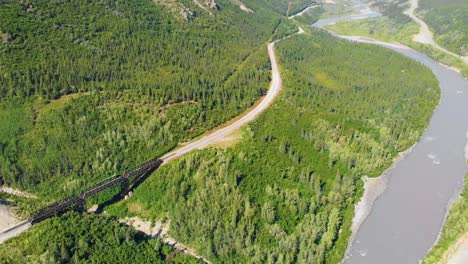 4K-Drone-Video-of-Train-Trestle-bridge-and-Mountains-Rising-above-the-Chulitna-River-near-Denali-National-Park-and-Preserve,-AK-during-Summer