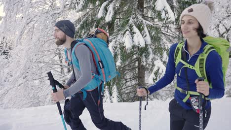 Feliz-Pareja-De-Esquiadores-Caminando-Con-Bastones-En-El-Paisaje-Nevado