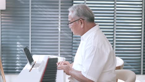 Älterer-Asiatischer-Mann,-Der-Mit-Hilfe-Einer-Virtuellen-Klasse-Das-Zwitschern-Lernt