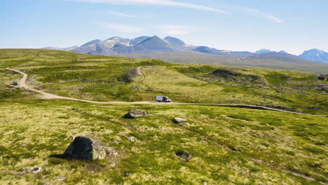 Aerial-View-Of-The-Campcar-On-The-Dirt-Path-Of-The-Green-Valley-In-Rondane-National-Park