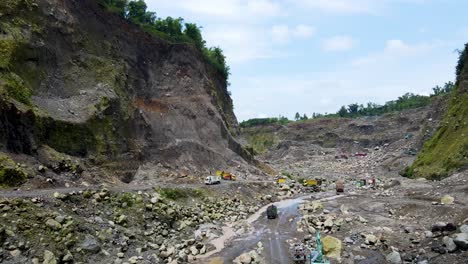 Open-pit-sand-mine-in-canyon-at-foot-of-Mount-Merapi,-Indonesia,-aerial-view