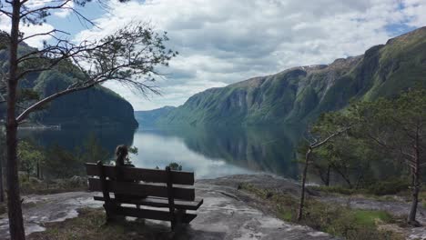 Woman-relaxing-on-bench-viewing-picture-perfect-Sorfjorden-Fjord-Norway---Stanghelle-western-Norway