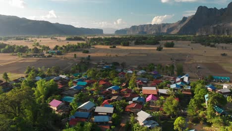 Aerial-drone-view-of-village-near-Kong-Lor-Cave,-Laos,-beautiful-landscape,-houses-and-mountains