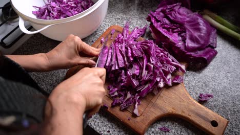 Chopping-Red-Cabbage-On-Wooden-Chopping-Board-At-The-Kitchen