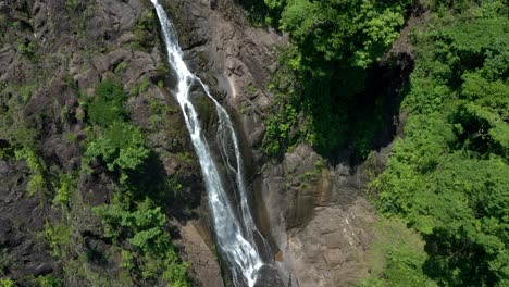 Aerial-shot-of-a-tall-and-thin-waterfall-in-a-rainforest-in-Costa-Rica