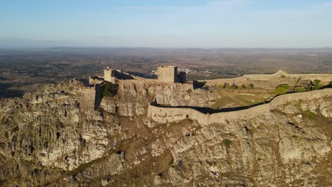 A-drone-flies-through-a-flock-parallel-with-the-Marvão-Castle-and-surrounding-village