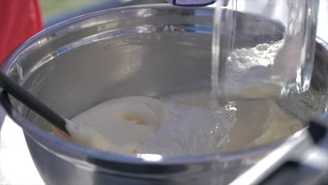 Close-up-gimbal-shot-of-flour-being-added-to-dough