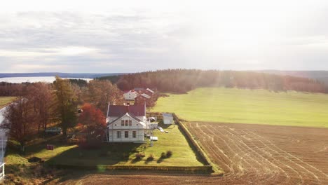 Lonely-White-Farm-House-Near-Ostersund,-Sweden-Field-During-Bright-Sunlight