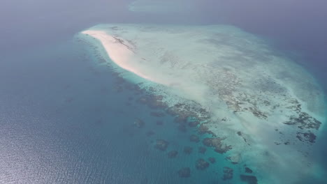 Hohe-Luftaufnahmen-Nähern-Sich-Einer-Kleinen-Sandinsel-Im-Flachen-Korallenriffmeer