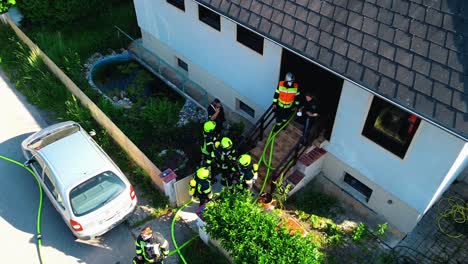 AERIAL---Firefighters-talking-outside-after-a-fire-in-Oberwaltersdorf,-Austria