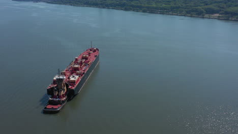 A-drone-view-of-a-large-red-barge-on-the-Hudson-River-in-NY-on-a-sunny-day