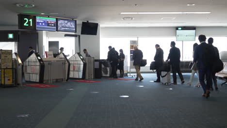 Warteschlange-Von-Passagieren,-Die-Während-Der-Pandemie-In-Tokio,-Japan,-Am-Flugsteig-Des-Flughafens-Haneda-Das-Flugzeug-Besteigen