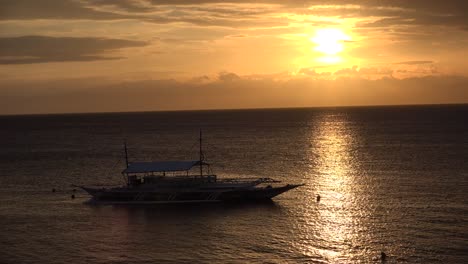 Sonnenuntergang-Mit-Sonnenlicht,-Das-Sich-Auf-Der-Meeresoberfläche-Spiegelt,-Und-Traditionellem-Philippinischem-Banka-Boot-Im-Vordergrund