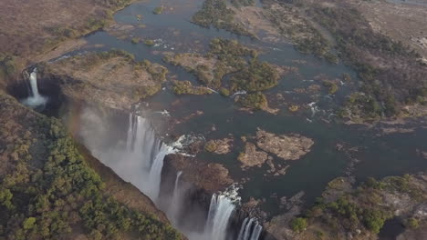 Rainbow-forms-during-rotating-aerial-of-UNESCO-famous-Victoria-Falls